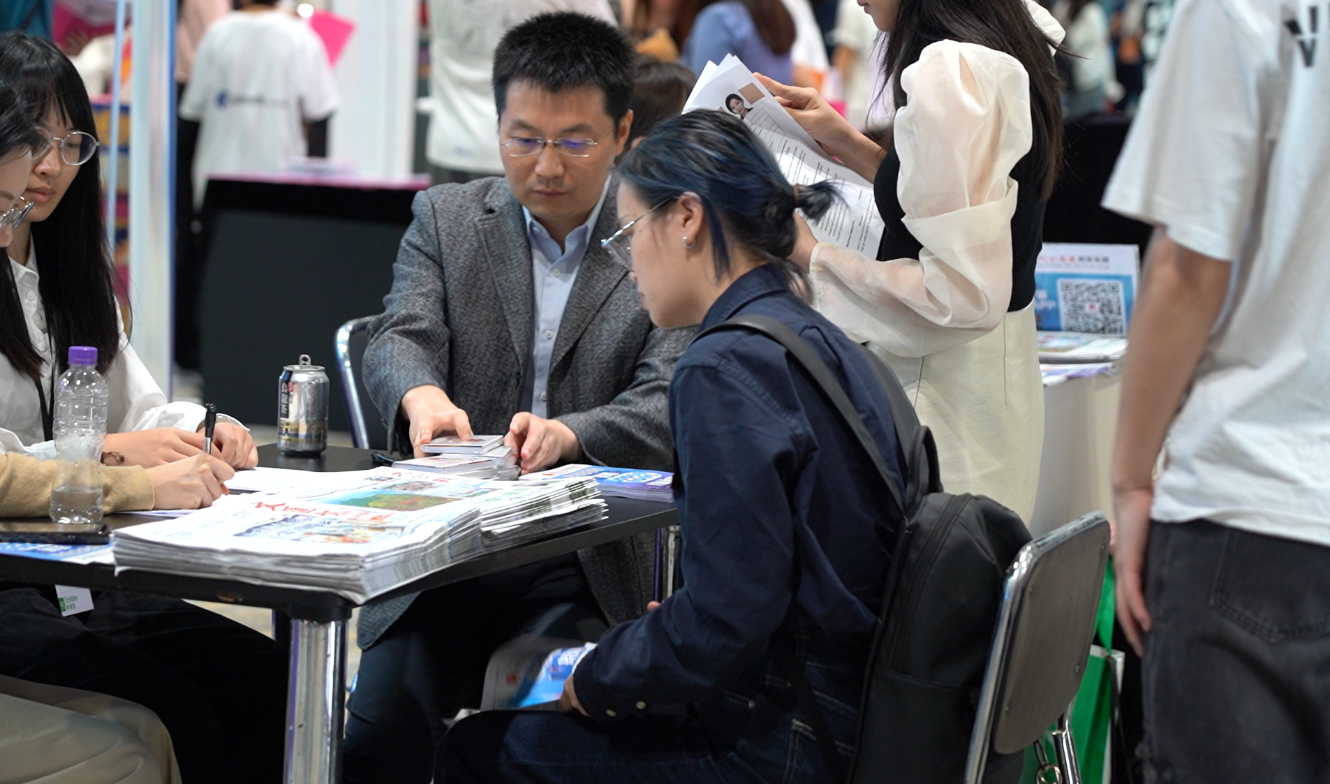 Half wide shot of a student talking to a HR at the job fair.(Source: Liu Xuetao)