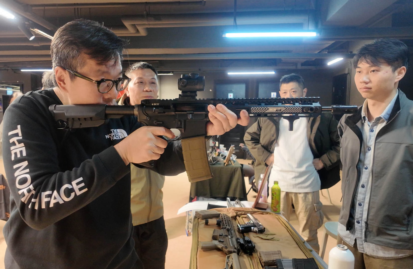 Allen Lui (middle) introducing one of the signature items for mainland tourists, the E&L 191 gas blowback rifle, a replica of China’s PLA’s latest standard-issue weapon. Credit: Yang Yihua